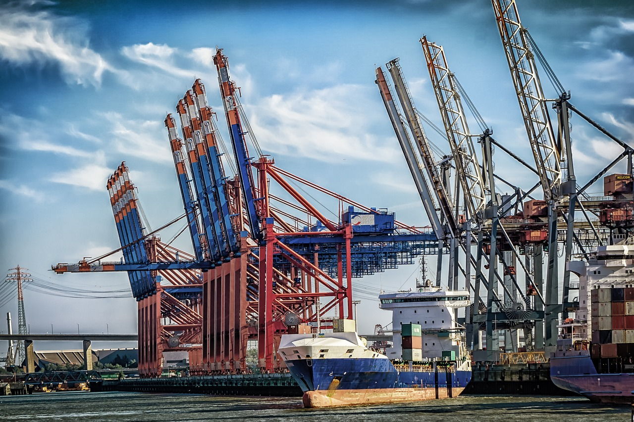 Вид морского порта с кранами и контейнерами. Иллюстрация к статье про инвестиционные проекты в портовой инфраструктуре.